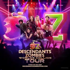 Seven energetic performers in vibrant costumes pose before a large red apple and colorful Z logo, promoting the Descendants & Zombies Worlds Collide Tour. Tour info, website, and details on free tickets are displayed at the bottom.