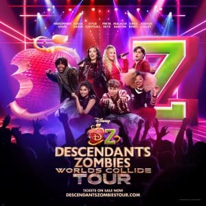 A promotional poster for Disneys Descendants Zombies Worlds Collide Tour features seven cast members posing energetically in front of a large red apple and green Z. Tour and ticket information is displayed at the bottom.
