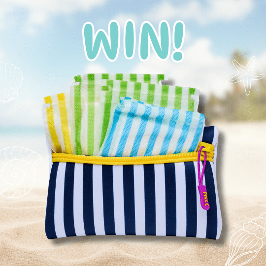 A Pinkies Prep Pouch filled with colorful striped cloths sits on sandy beach with seashell and starfish drawings. WIN! is written in bold letters above the pouch, set against a bright, sunny beach scene in the background.